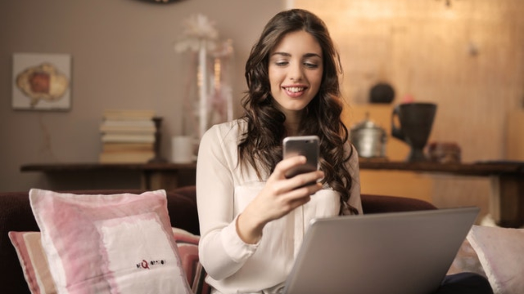 woman-sitting-on-sofa-while-looking-at-phone-with-laptop-on-920382 (2)